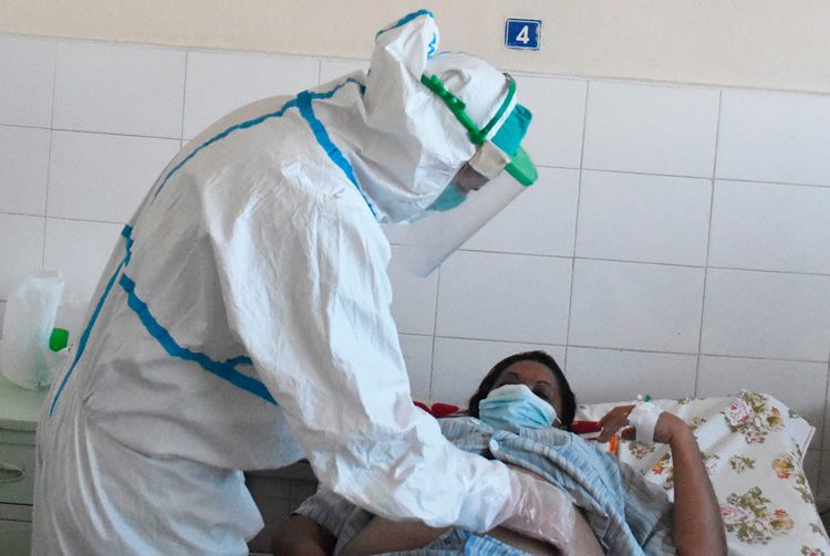 Yoan Pérez Ojeda atiente a paciente en la sala para pacientes con COVID-19.