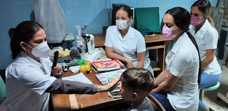 La Dra. Lyane González Morales, junto con alumnas de la especialidad, examina a un pequeño en la consulta. (Foto: Ricardo R. González)