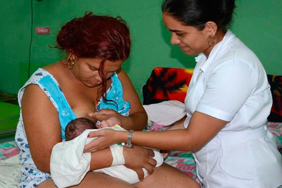 Enfermera atendiendo a una madre que realiza la lactancia materna.