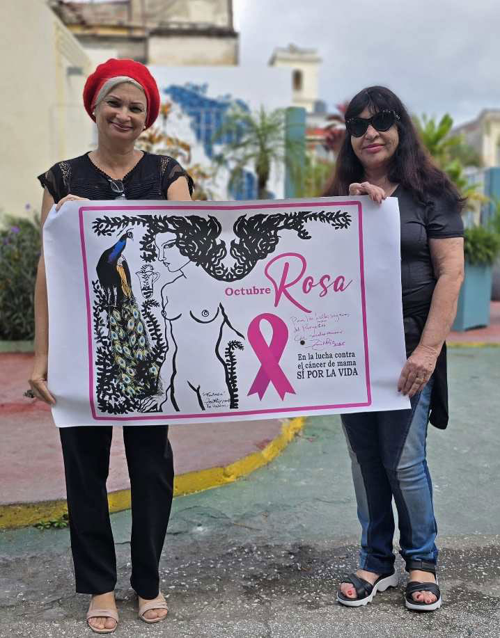 Zaida del Río entrega su obra a Liudmila Valdés, del proyecto Octubre Rosa, de lucha contra el cáncer de mama.