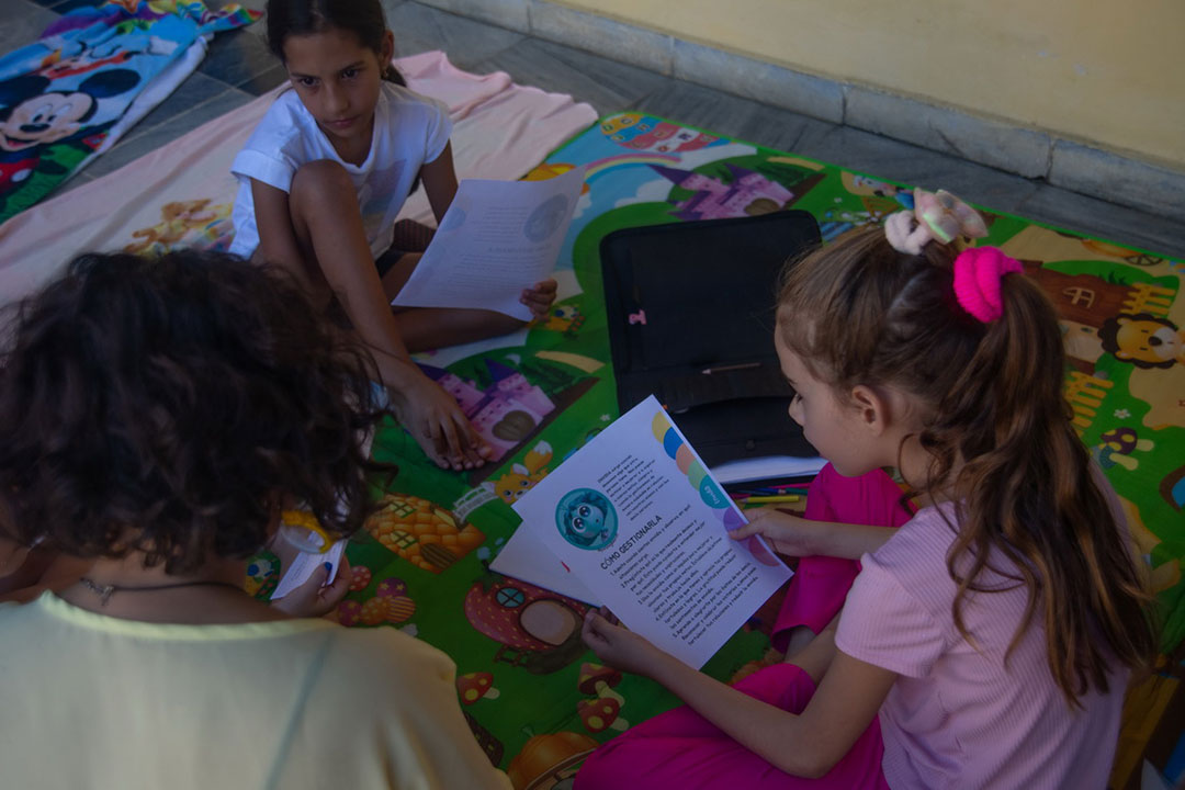 Niños con manual del proyecto Yoga Alegría.