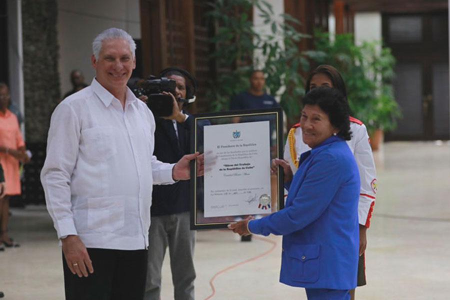 Presidente cubano, Miguel Díaz-Canel, condecora a Heroína del Trabajo.