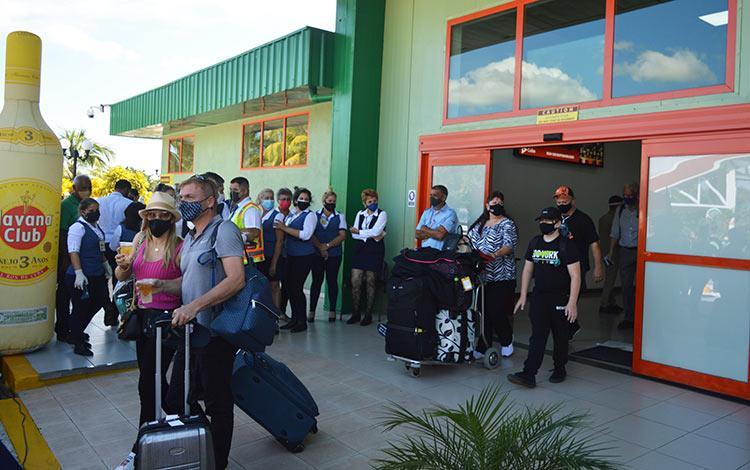 Viajeros del primer vuelo de primer vuelo de Sunwing Airlines tras su arribo al aeropuerto internacional Abel Santamarí­a, de Villa Clara.