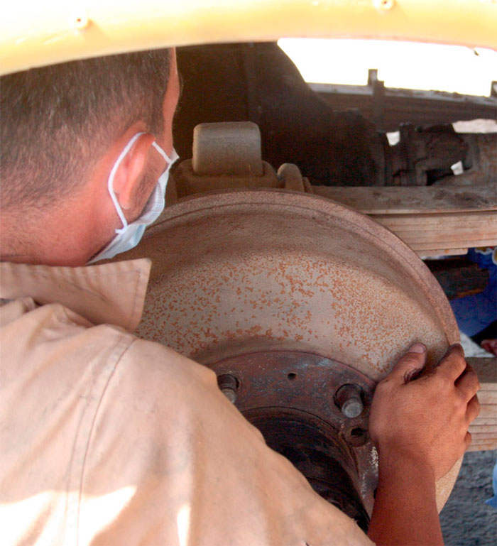 Mecánico reparando uno de los ómnibus de la Base de Transporte Escolar de Corralillo.